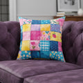 Colorful patchwork pillow with floral patterns on a white background
