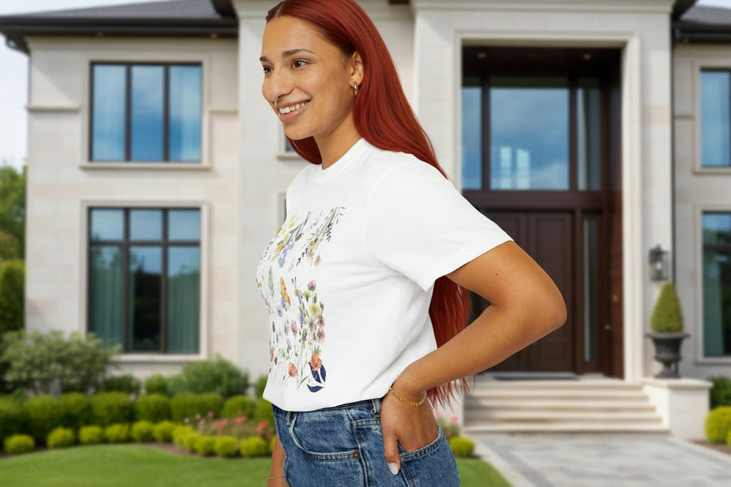 Woman wearing a white t-shirt with colorful graphics and blue jeans on a white background