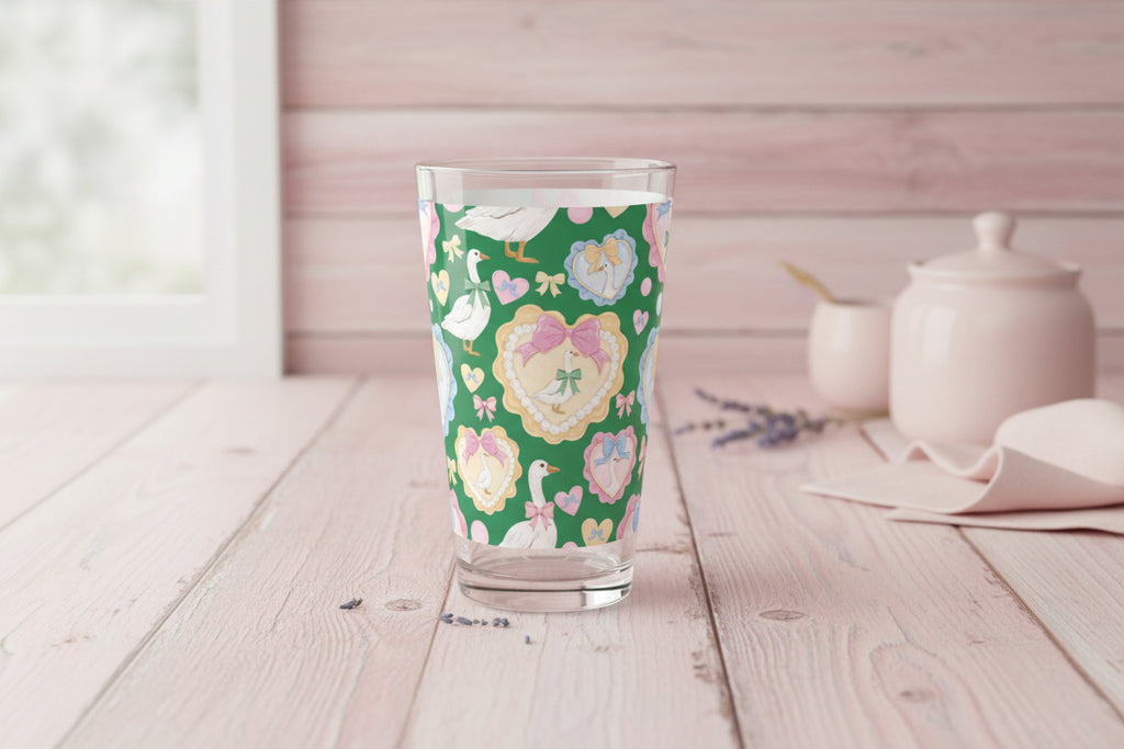 Clear glass tumbler with a floral and duck pattern on a green background