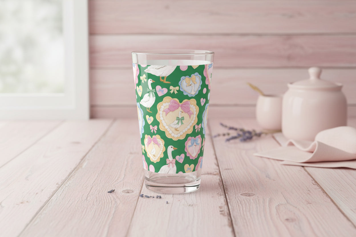 Clear glass tumbler with a floral and duck pattern on a green background