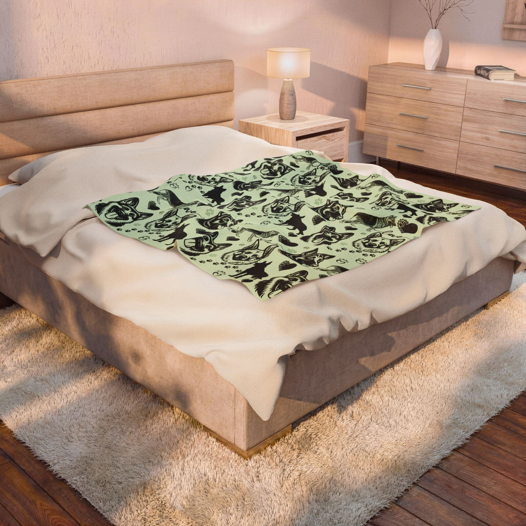 Bedroom with a bed featuring a green blanket with black patterns