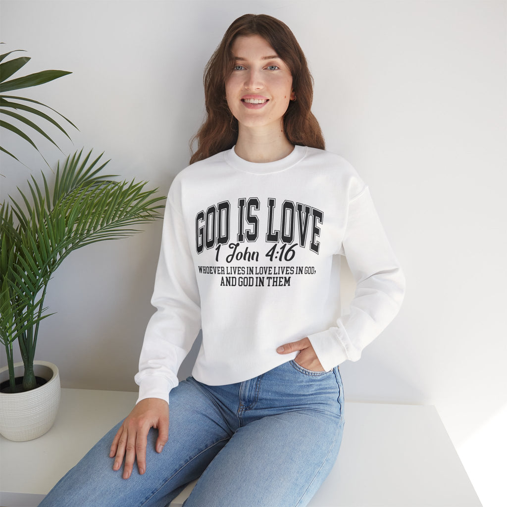 Woman wearing a white sweatshirt with 'GOD IS LOVE' text, sitting in a room with a plant.