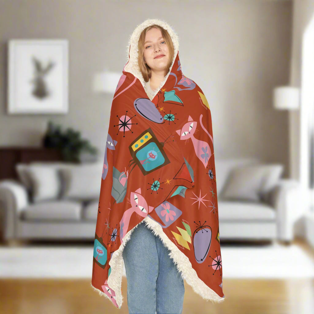 Person wrapped in a colorful blanket with abstract designs on a white background