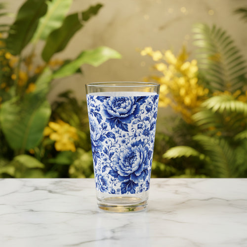A clear drinking glass with a blue and white floral peony pattern, shown on a solid white background.