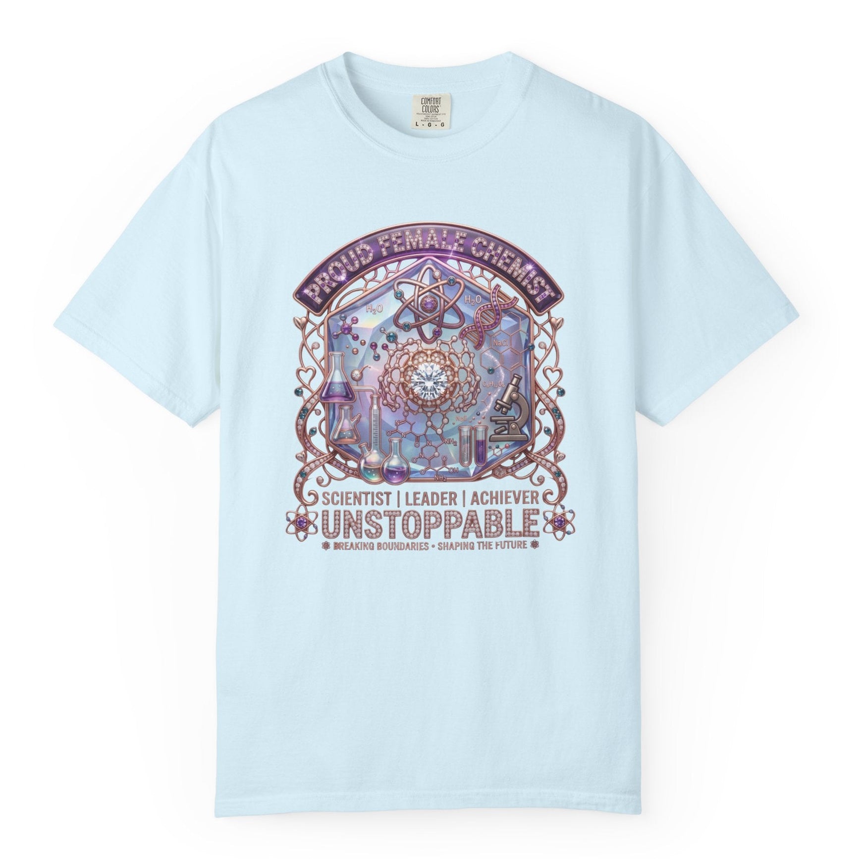 A light blue short-sleeve crewneck t-shirt with a colorful graphic on the front featuring a dreamcatcher and the text 'PROUD FEMINIST CHEMIST', 'SCIENTIST | LEADER | ACHIEVER', and 'UNSTOPPABLE'.