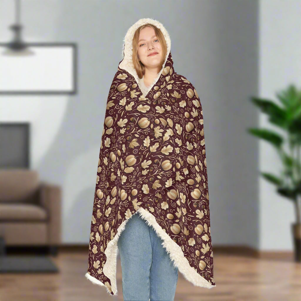 Person wrapped in a patterned blanket with a hood on a white background