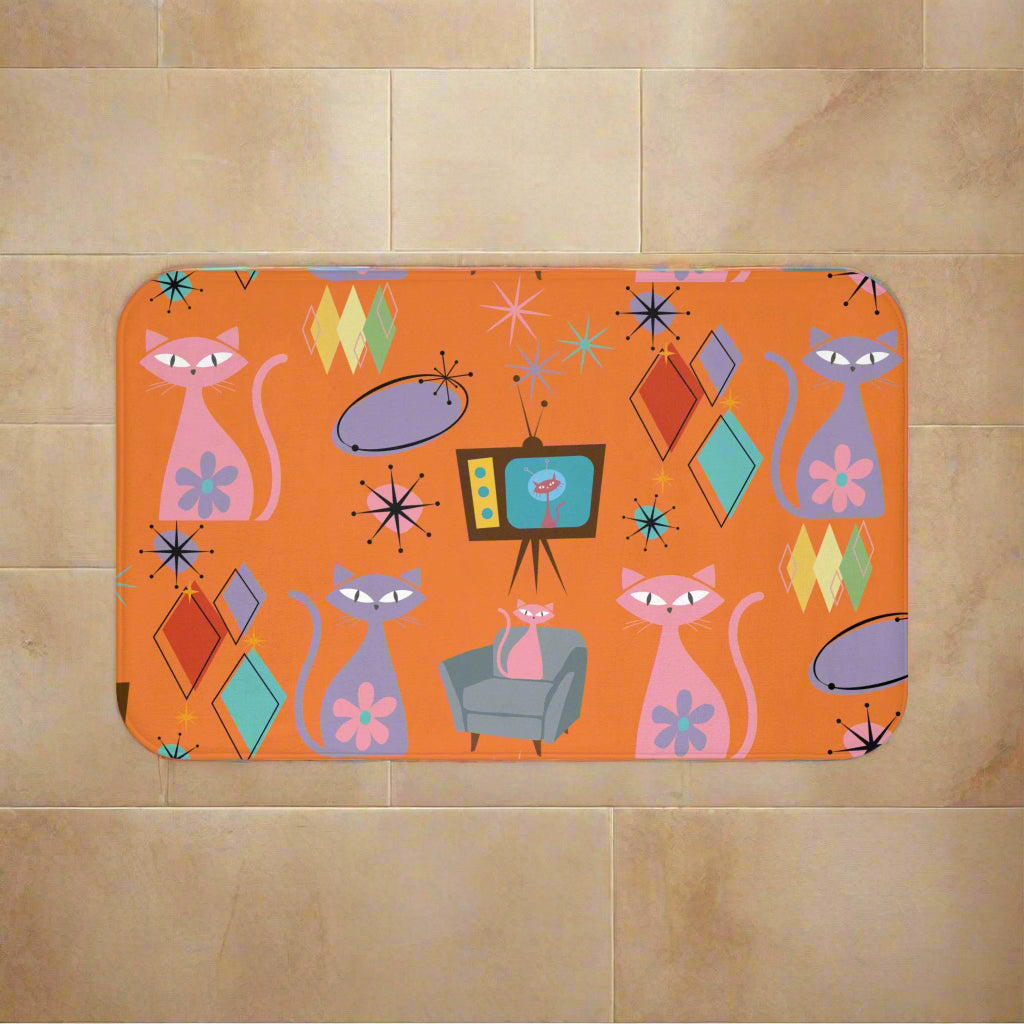 Colorful patterned place mat with cats and geometric shapes on an orange background