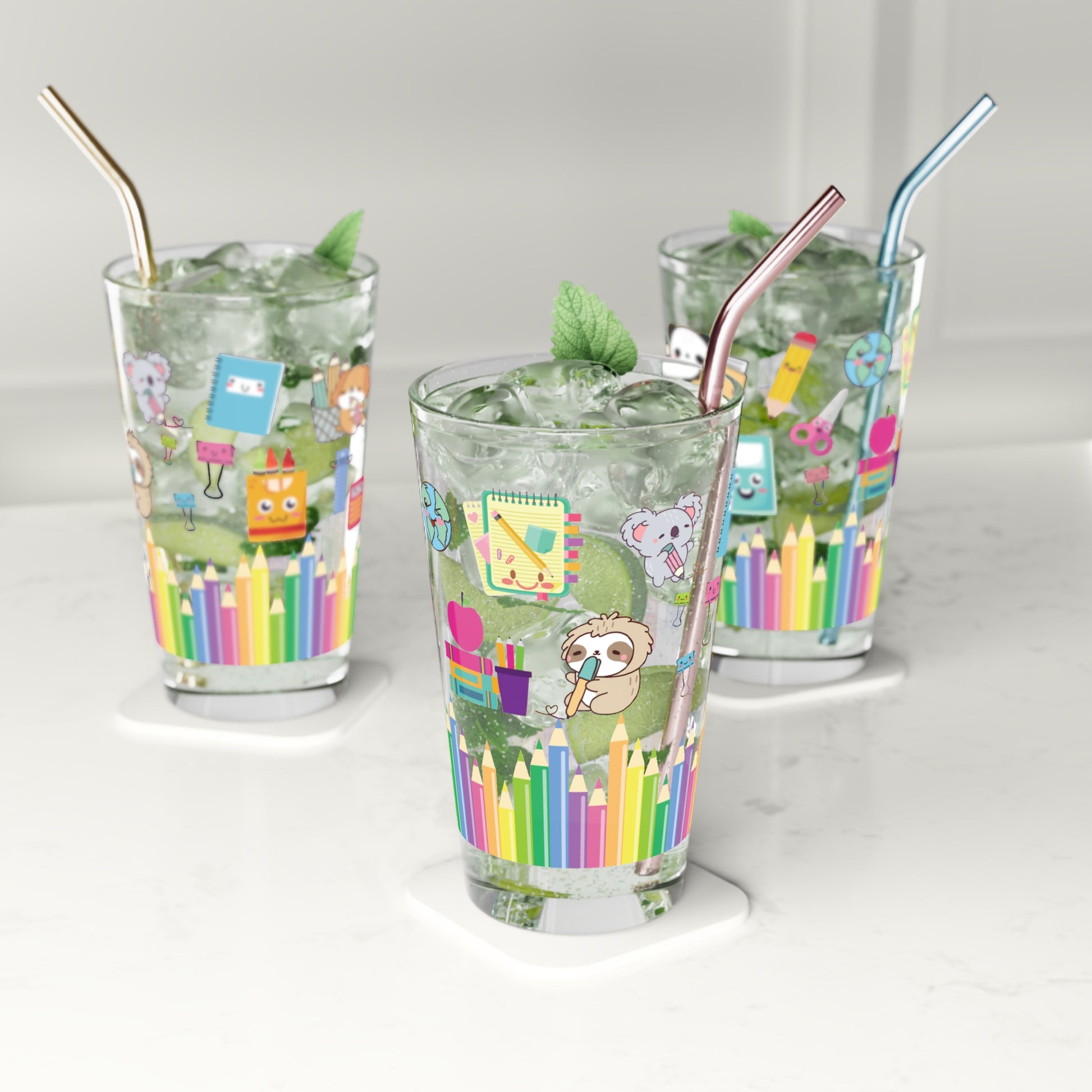 Three glasses with colorful designs and straws on a white background