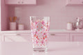 Clear glass with pink bow and heart pattern on a white background