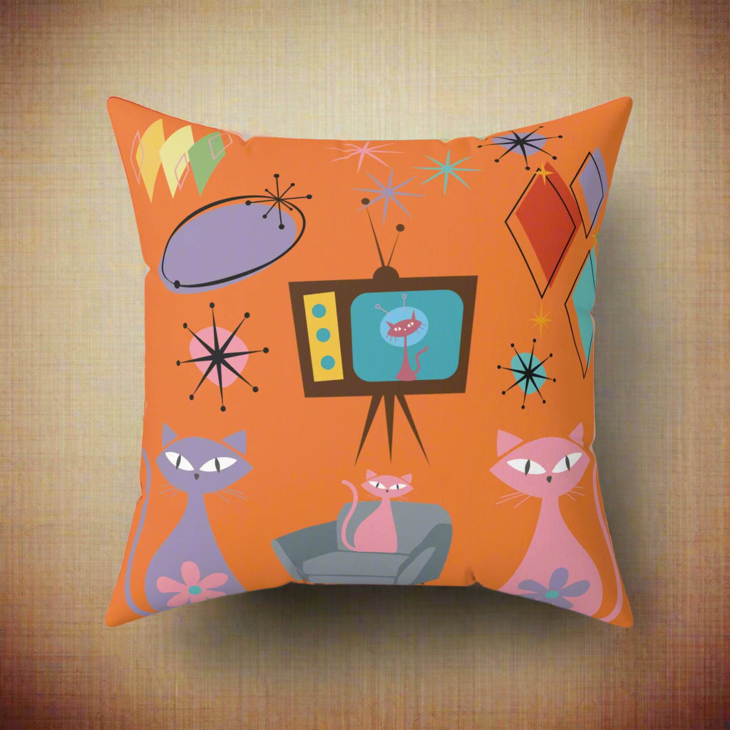 Decorative pillow with retro design featuring cats, a TV, and abstract shapes on an orange background.