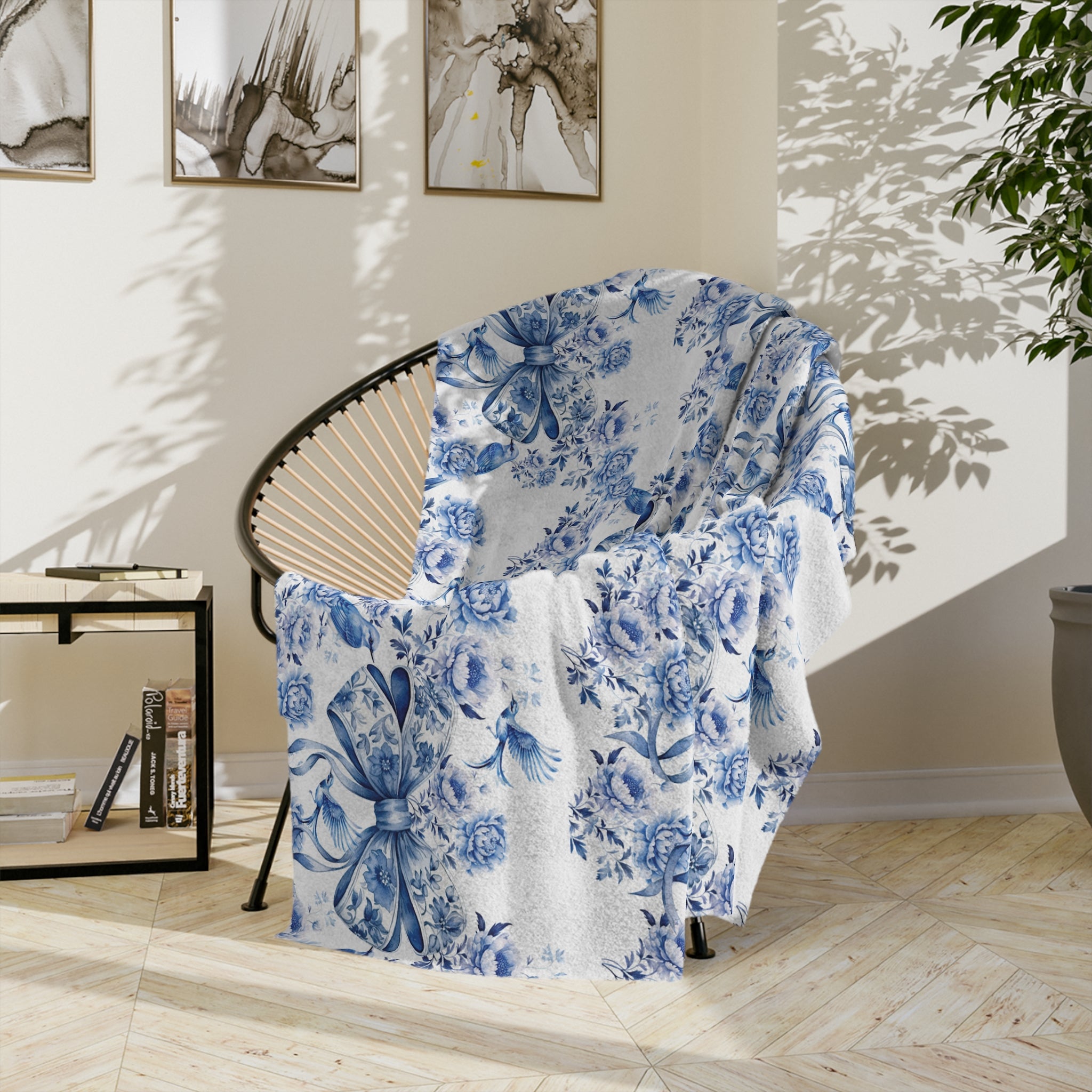 A blue and white floral patterned blanket with a bow draped over a chair in a room with light decor.