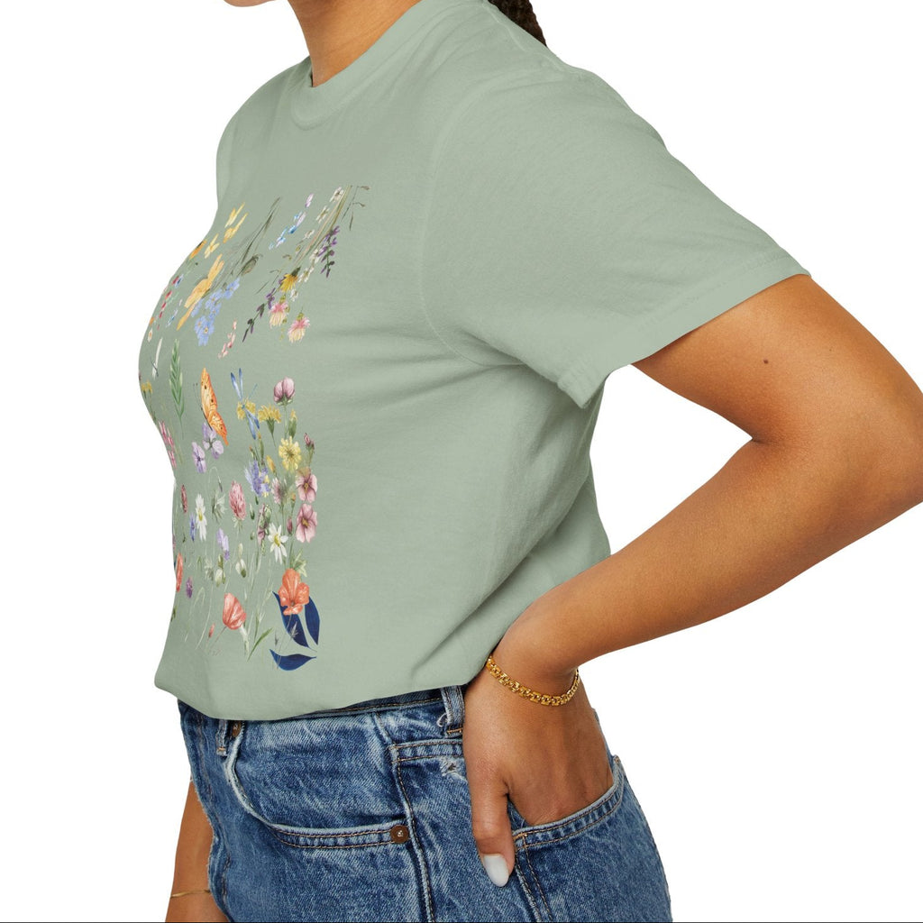 Woman wearing a light green t-shirt with floral designs on a white background