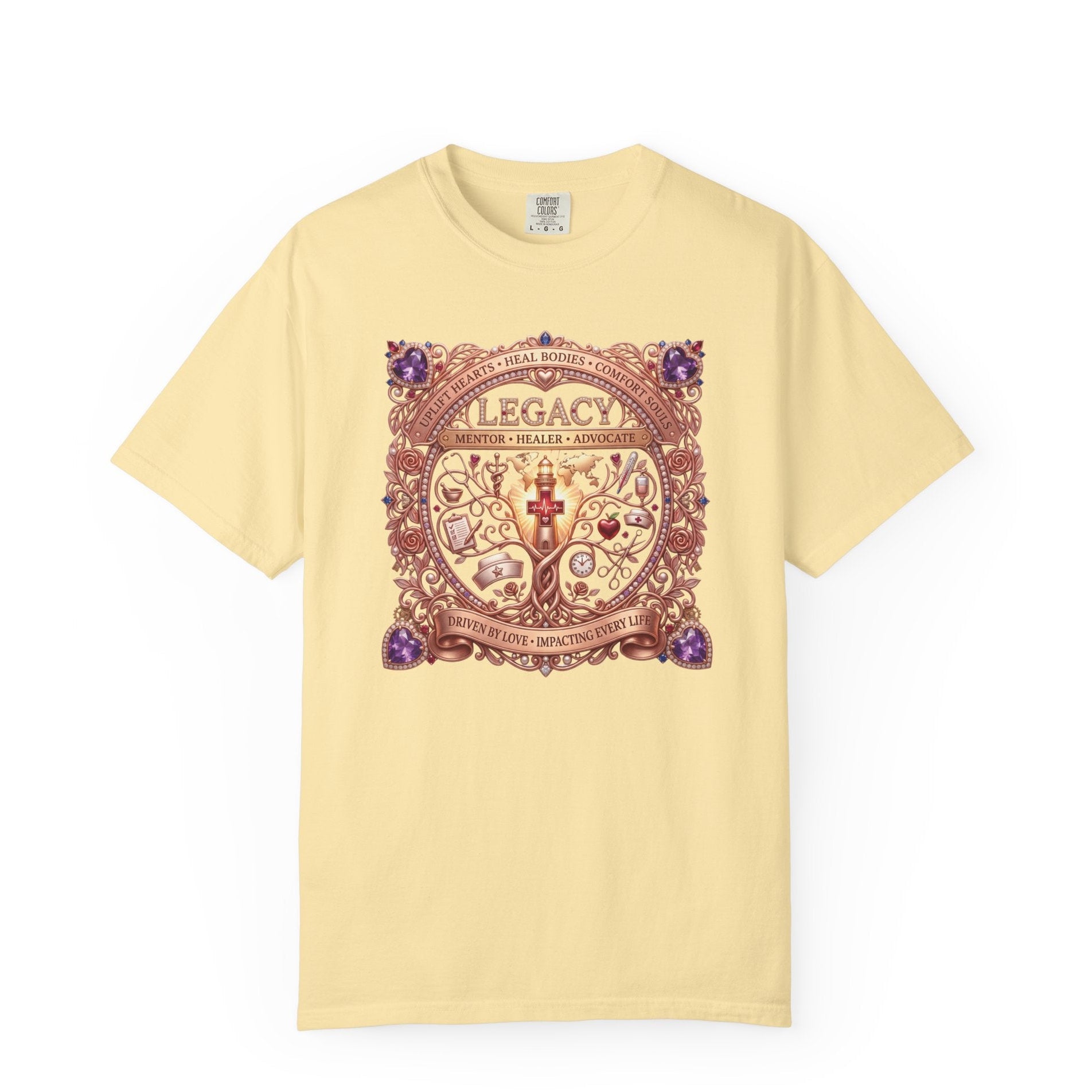 A pale yellow short-sleeve t-shirt with a large, ornate vintage-style graphic on the chest featuring the word 'LEGACY' and intricate decorative details in purple, brown, and gold tones.