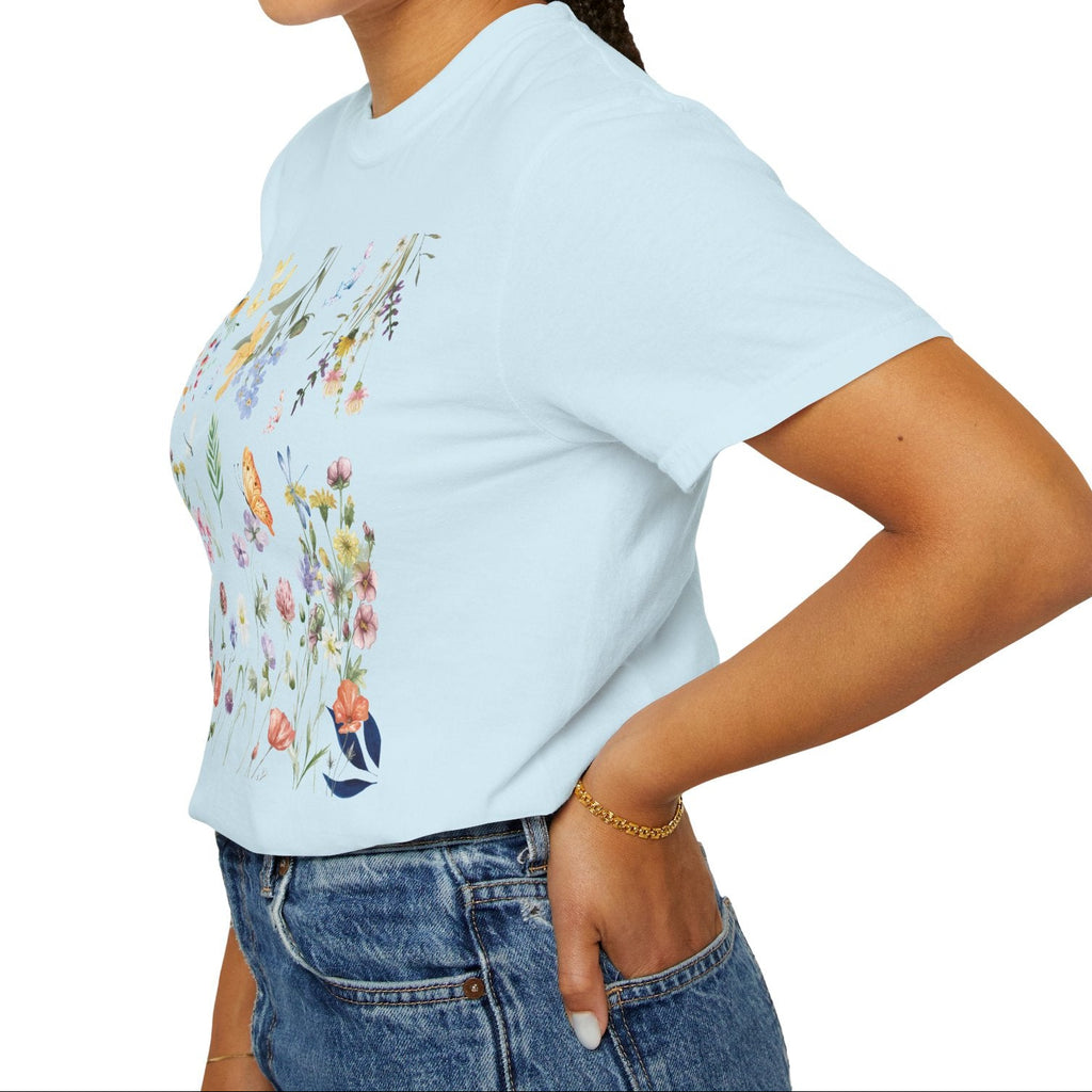 Woman wearing a light blue t-shirt with a colorful graphic design on a white background