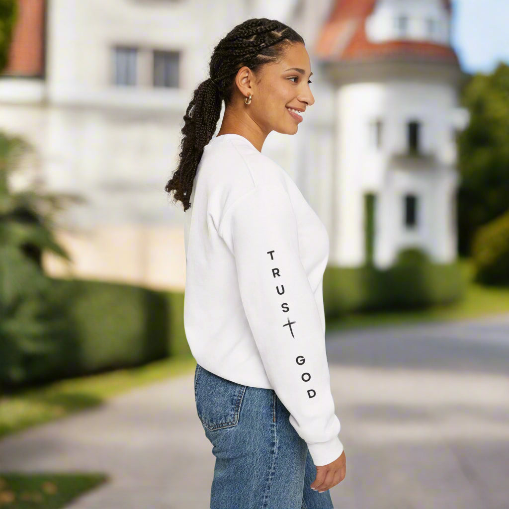 Woman wearing a white sweatshirt with 'Trust God' text on a white background