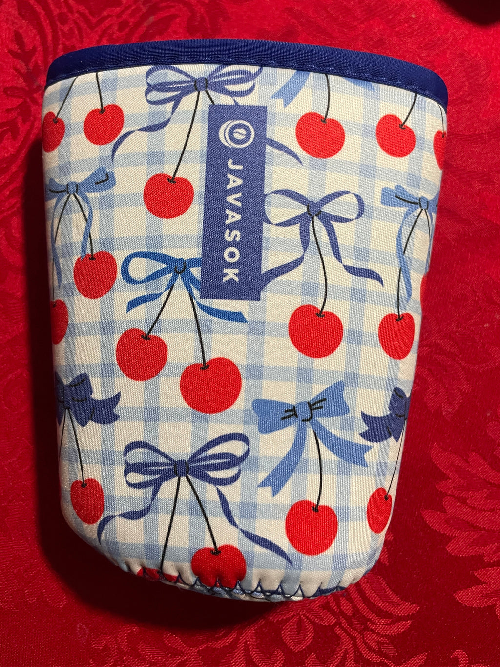 Small pouch with cherry and bow pattern on a red background, featuring the brand 'Javasok'.